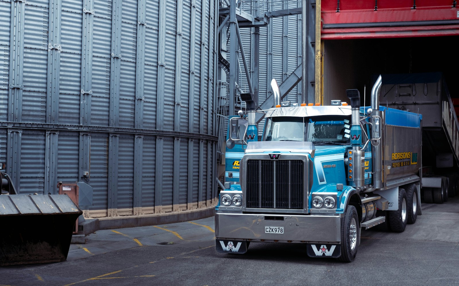 a large blue truck parked in front of a building